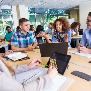 Group of teenage students studying at a library table.